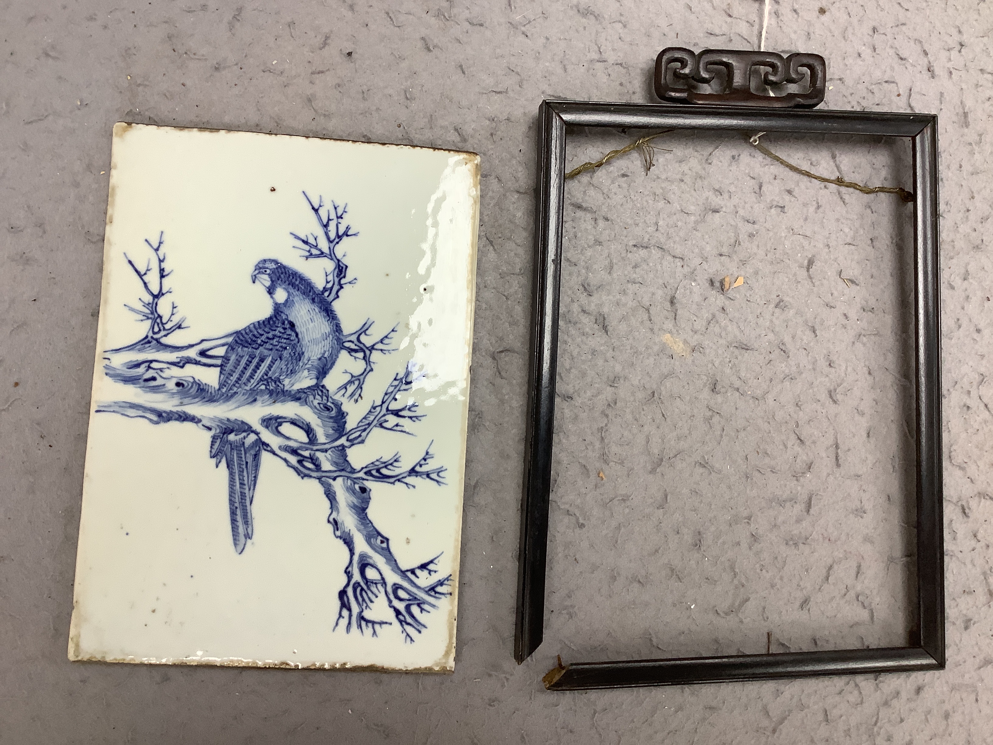 A late 19th century Chinese blue and white plaque of a bird, ebonised frame, 19cm wide x 30cm high including frame